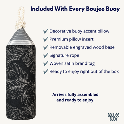 A black Boujee Bouy decorative buoy with a white tropical leaf pattern, shown on a light beige background with promotional text detailing what is included with every Boujee buoy.